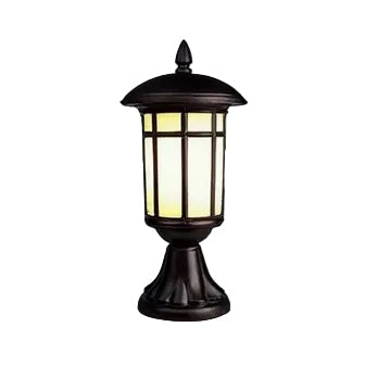 A classic outdoor table lamp with a dark bronze metal frame and a warm yellow glowing light, shown against a plain white background.