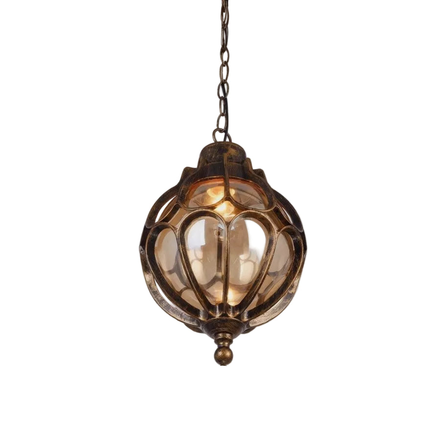 An antique bronze hanging lantern light fixture with a warm glowing bulb inside, set against a plain white background.