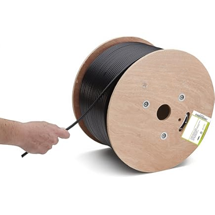 Hand holding a spool of black cable against a white background